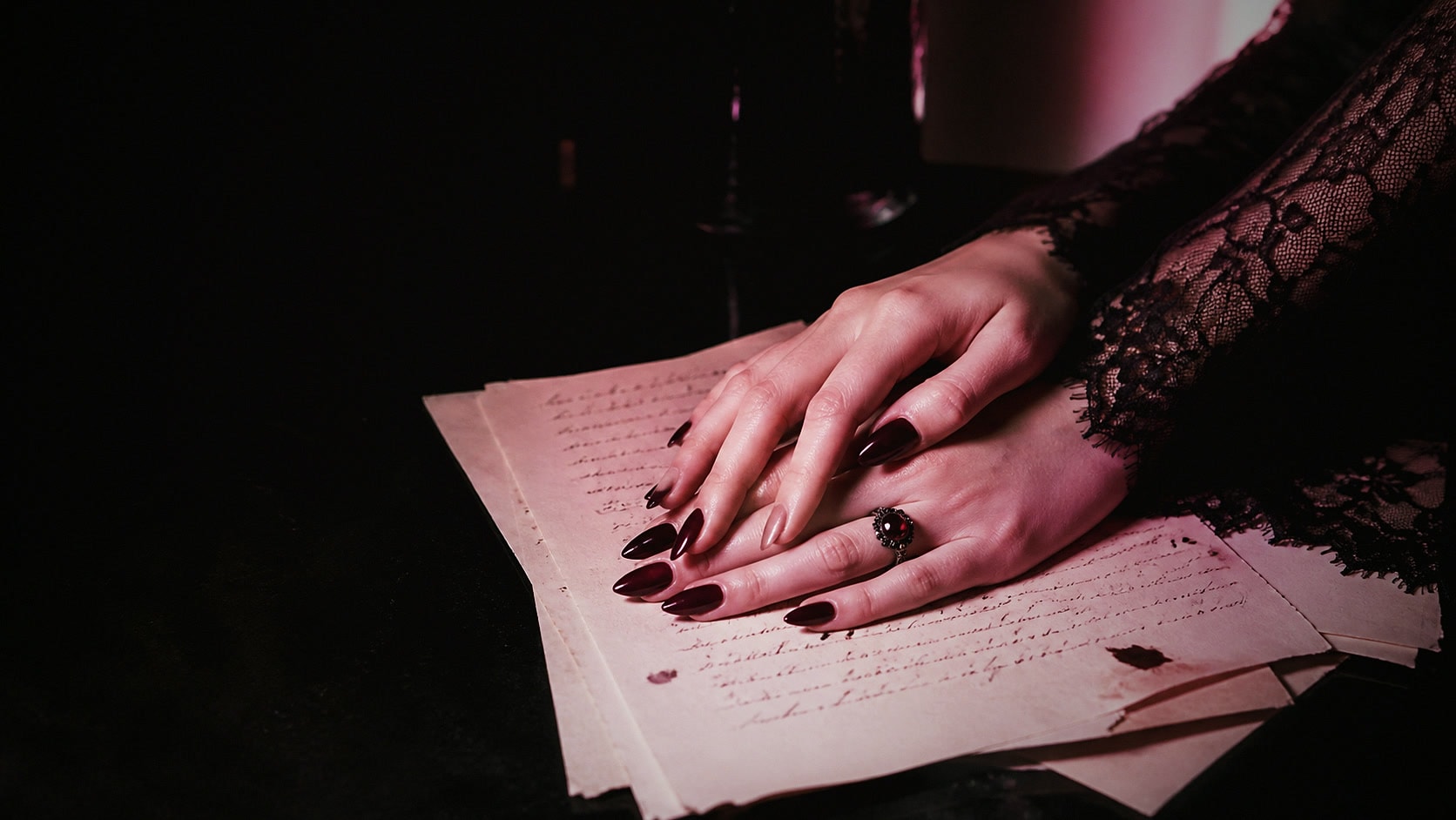Hands resting on handwritten manuscript pages